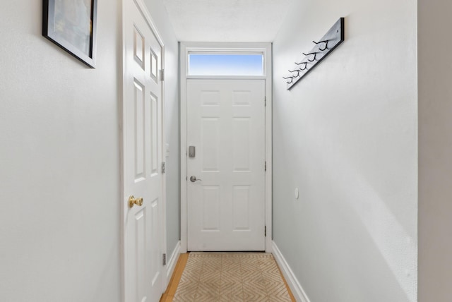 doorway featuring baseboards