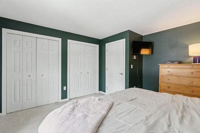 carpeted bedroom featuring multiple closets