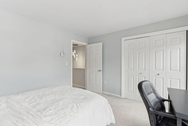 bedroom featuring light carpet, baseboards, and a closet