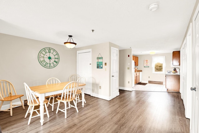 dining space featuring baseboards and wood finished floors