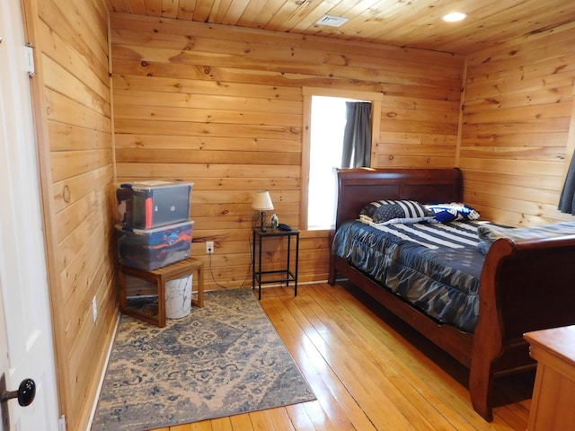 bedroom featuring light wood finished floors, wood walls, and wood ceiling