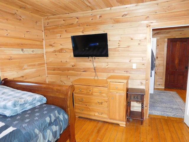 bedroom featuring wood ceiling, light wood-style floors, and wood walls