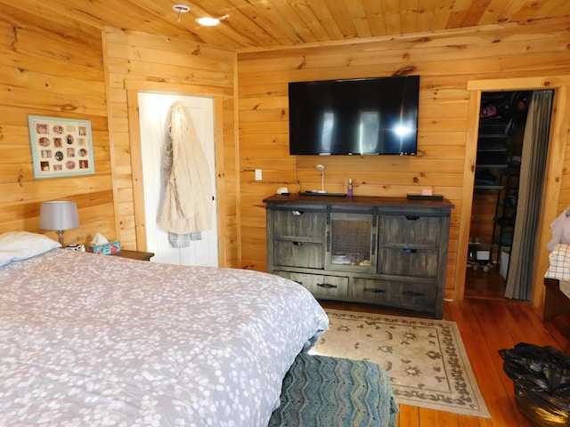 bedroom featuring wood finished floors, wooden ceiling, and wood walls