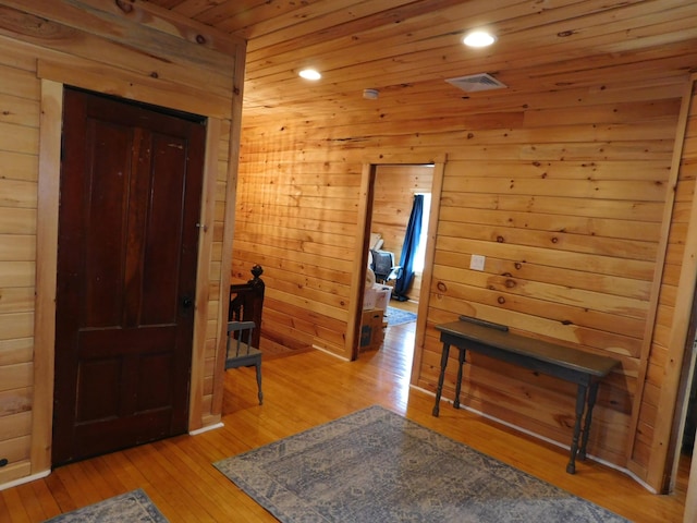 corridor featuring recessed lighting, light wood-style flooring, wooden ceiling, and wood walls