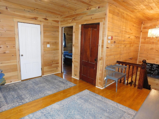 bedroom featuring hardwood / wood-style floors, wooden ceiling, and wooden walls