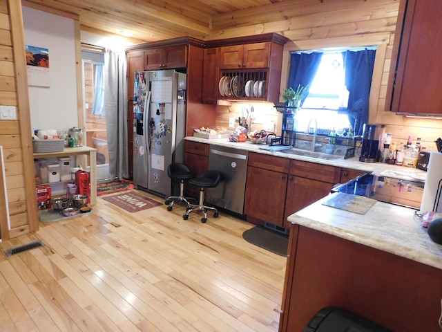 kitchen featuring a sink, light wood-style floors, appliances with stainless steel finishes, and light countertops