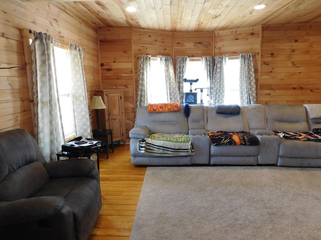 living room featuring plenty of natural light, wooden walls, and wood ceiling