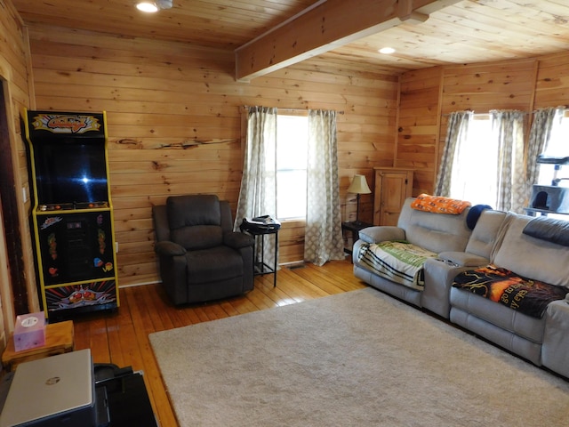 living room with beam ceiling, wooden walls, wood ceiling, and hardwood / wood-style flooring