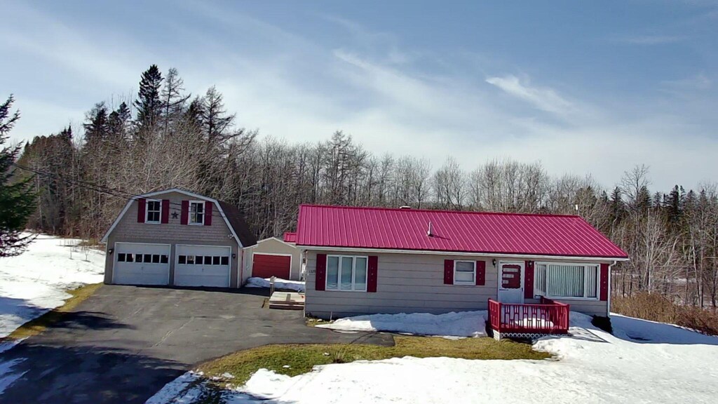 1329 Presque Isle Rd, Caribou, ME 04736 - view of front of house featuring a wooded view, metal roof, a detached garage, and an outdoor structure