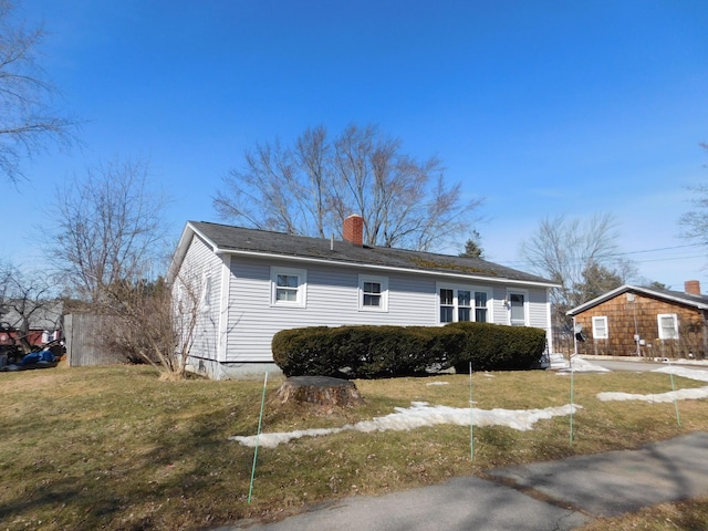 view of front of house with a front yard and a chimney