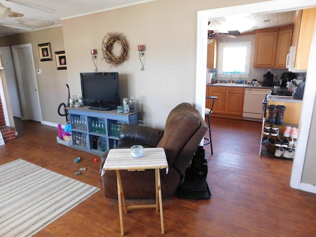 living area with dark wood finished floors, baseboards, a ceiling fan, and ornamental molding