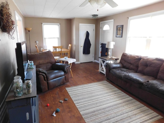 living room featuring baseboards, wood finished floors, and ceiling fan