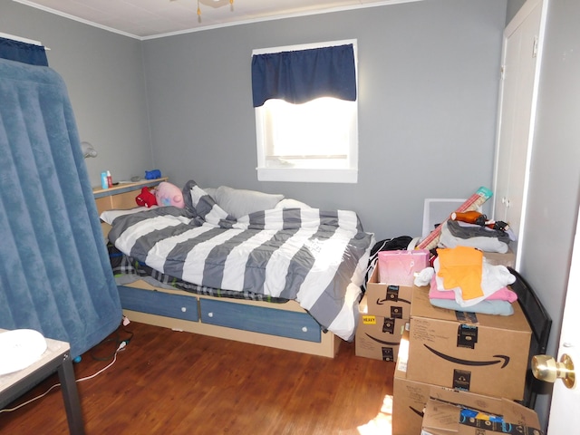 bedroom featuring crown molding and wood finished floors