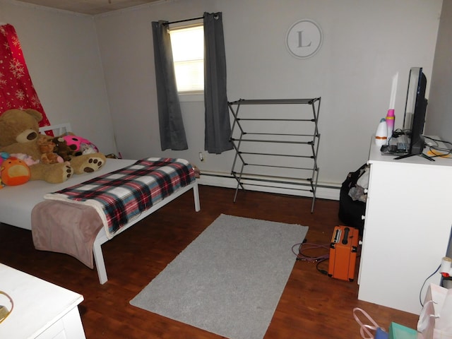 bedroom with a baseboard heating unit and wood finished floors