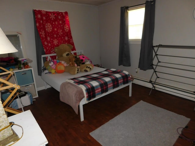 bedroom featuring baseboard heating and wood finished floors