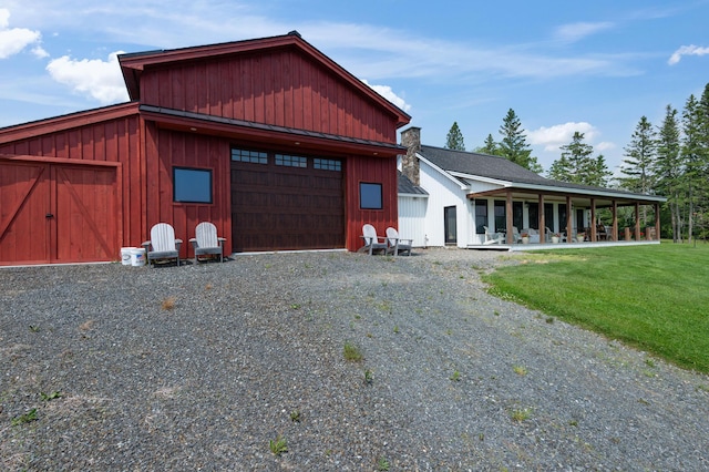 3062 Main St, Rangeley, ME 04970 - view of front of house with an outbuilding, board and batten siding, a front lawn, and driveway