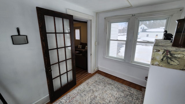 doorway to outside with baseboards and wood finished floors