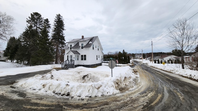 view of snowy exterior with a chimney