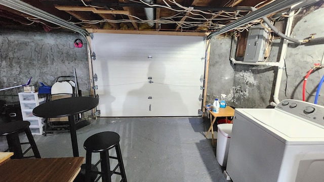 unfinished below grade area with electric panel and washer / clothes dryer