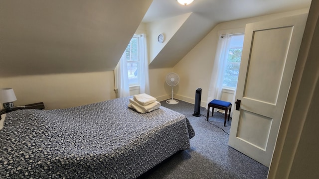 bedroom featuring lofted ceiling, baseboards, and dark carpet