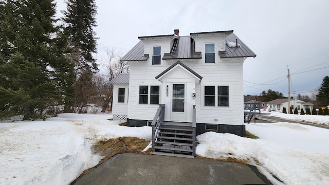 view of front facade with a chimney and metal roof