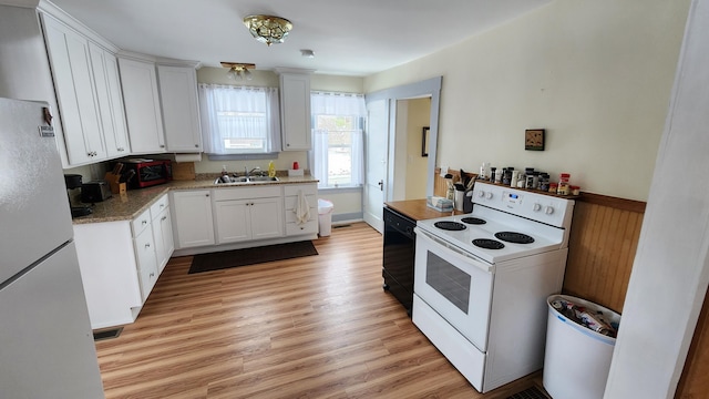 kitchen featuring a sink, white appliances, light wood-style flooring, and white cabinetry