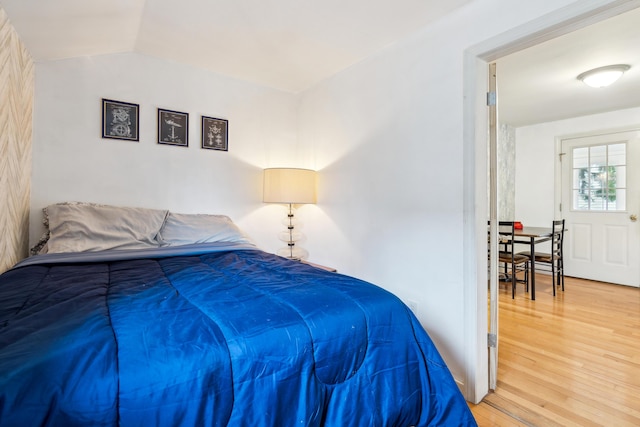 bedroom featuring lofted ceiling and light wood-style flooring