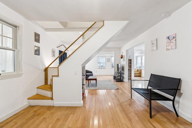 interior space with baseboards, light wood-style flooring, and stairs