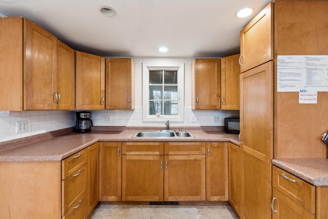 kitchen featuring backsplash, recessed lighting, black microwave, and a sink