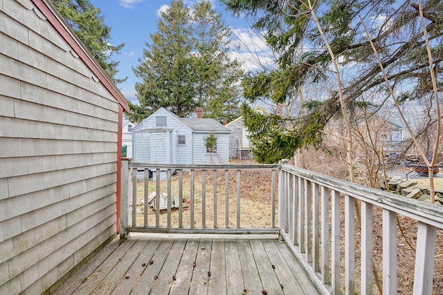 wooden deck with an outbuilding and a storage unit