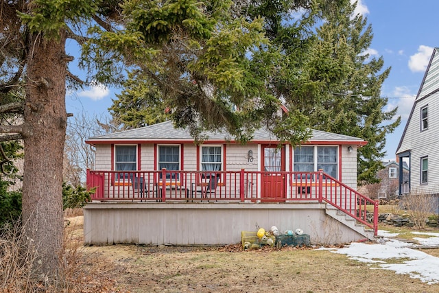 view of front of property featuring a shingled roof and stairs