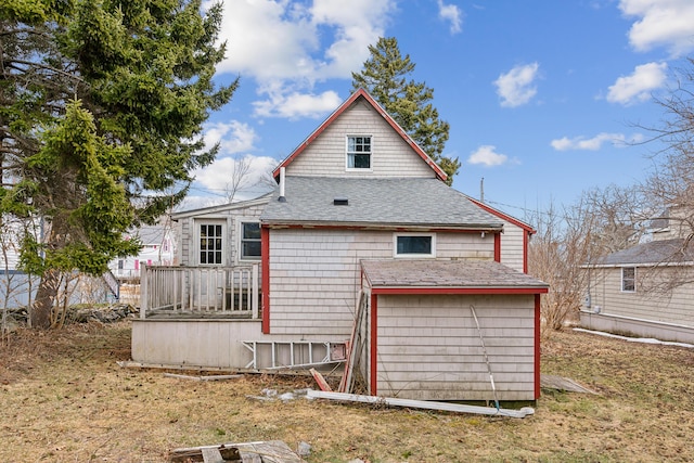 back of house featuring a garage and roof with shingles