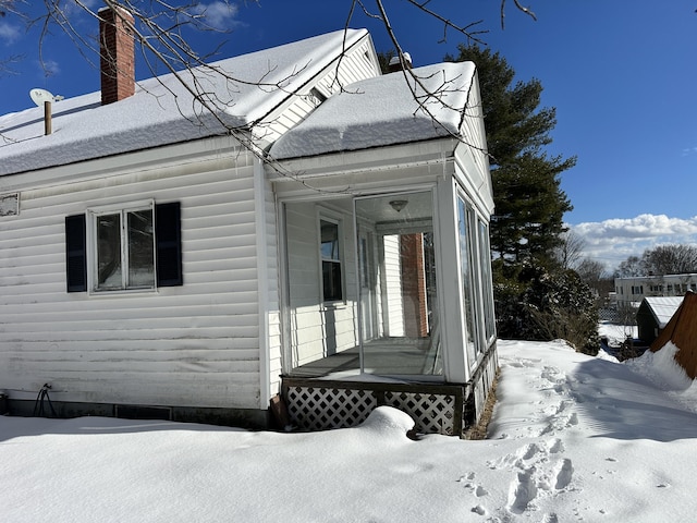 snow covered property featuring a chimney