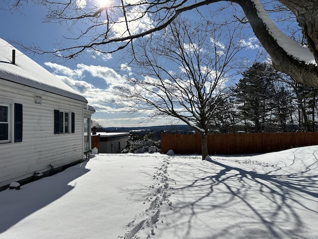 yard covered in snow featuring fence