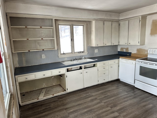 kitchen with white appliances, dark countertops, dark wood-style flooring, and a sink