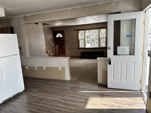 entryway featuring radiator heating unit, stairs, and wood finished floors