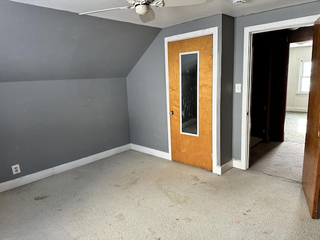 additional living space featuring carpet flooring, lofted ceiling, baseboards, and a ceiling fan