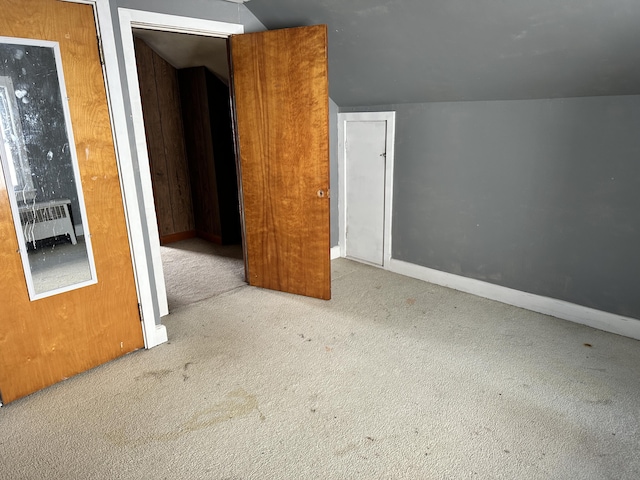 bonus room with baseboards, lofted ceiling, radiator, and carpet flooring