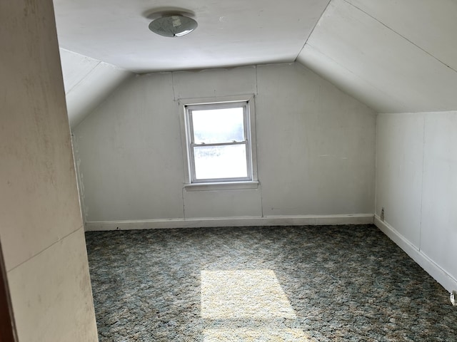 additional living space featuring baseboards, carpet flooring, and vaulted ceiling