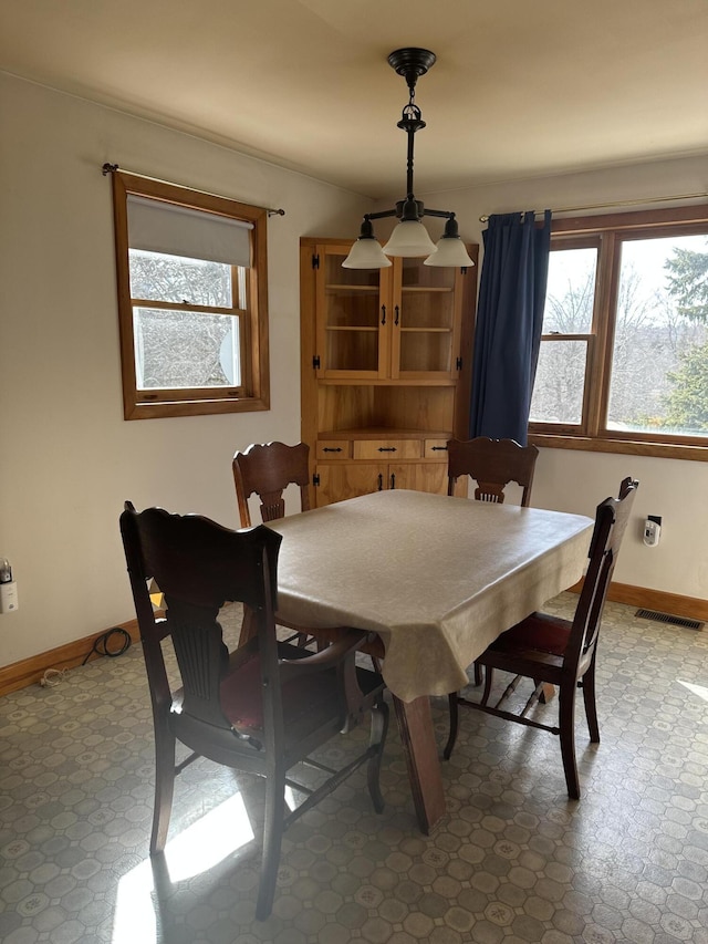 dining room featuring a wealth of natural light, visible vents, baseboards, and tile patterned floors