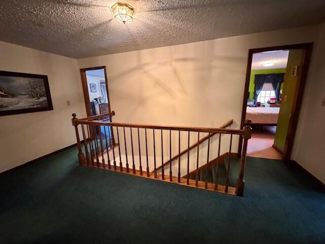 interior space with carpet, baseboards, and a textured ceiling