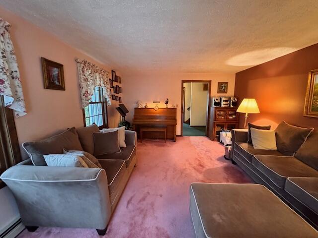 carpeted living room with a baseboard radiator and a textured ceiling