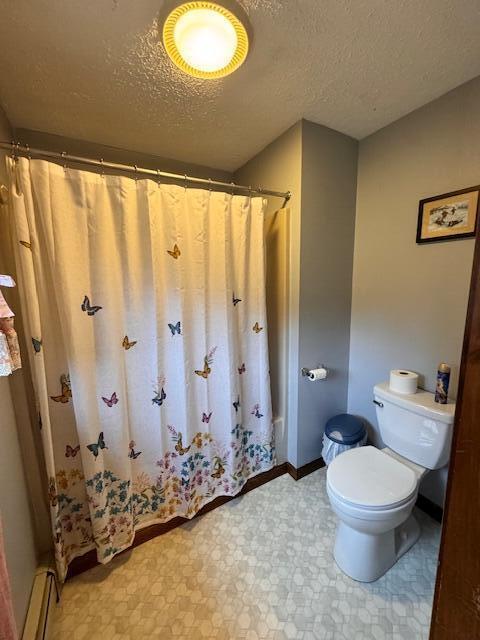 full bath with toilet, tile patterned floors, a baseboard heating unit, and a textured ceiling