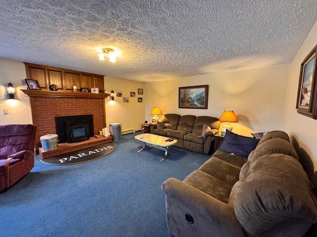 living area with a textured ceiling, carpet flooring, and a fireplace