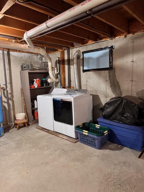 unfinished below grade area featuring washing machine and clothes dryer