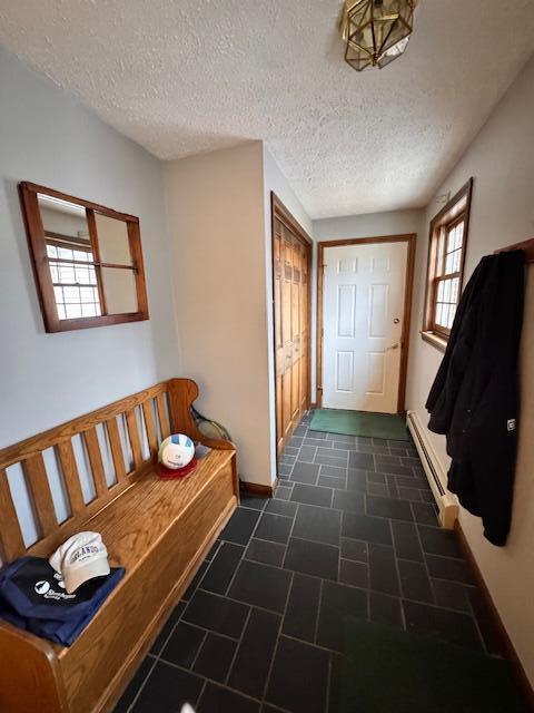 mudroom featuring baseboards and a textured ceiling