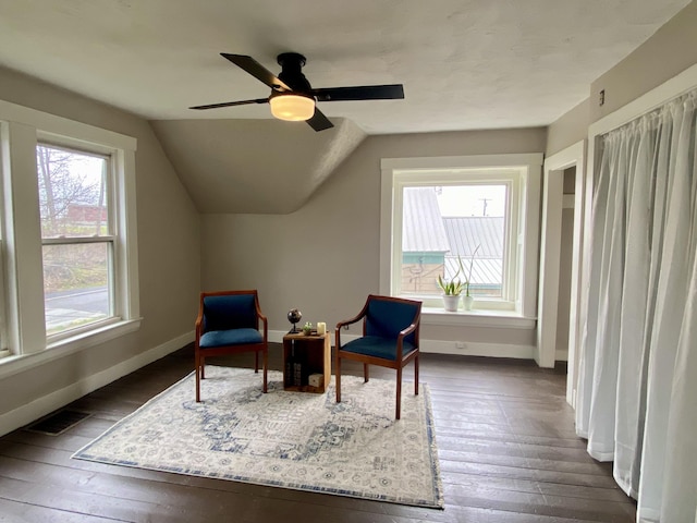 living area featuring dark wood-style flooring, baseboards, visible vents, and a ceiling fan