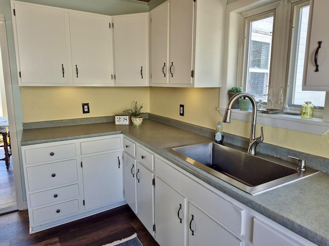 kitchen featuring a sink, white cabinets, and dark wood-style floors