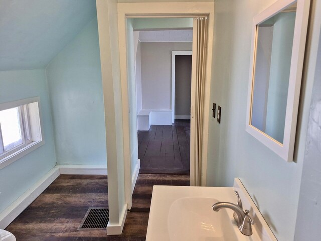 bathroom with baseboards, a sink, visible vents, and wood finished floors
