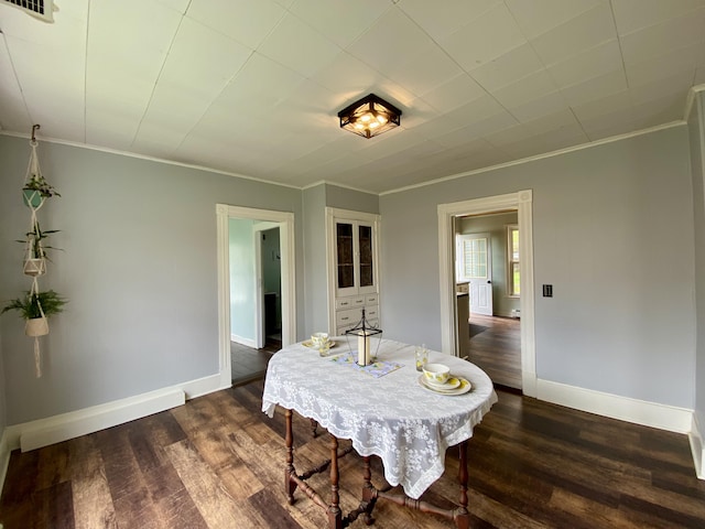 dining space with dark wood-style floors, baseboards, and ornamental molding